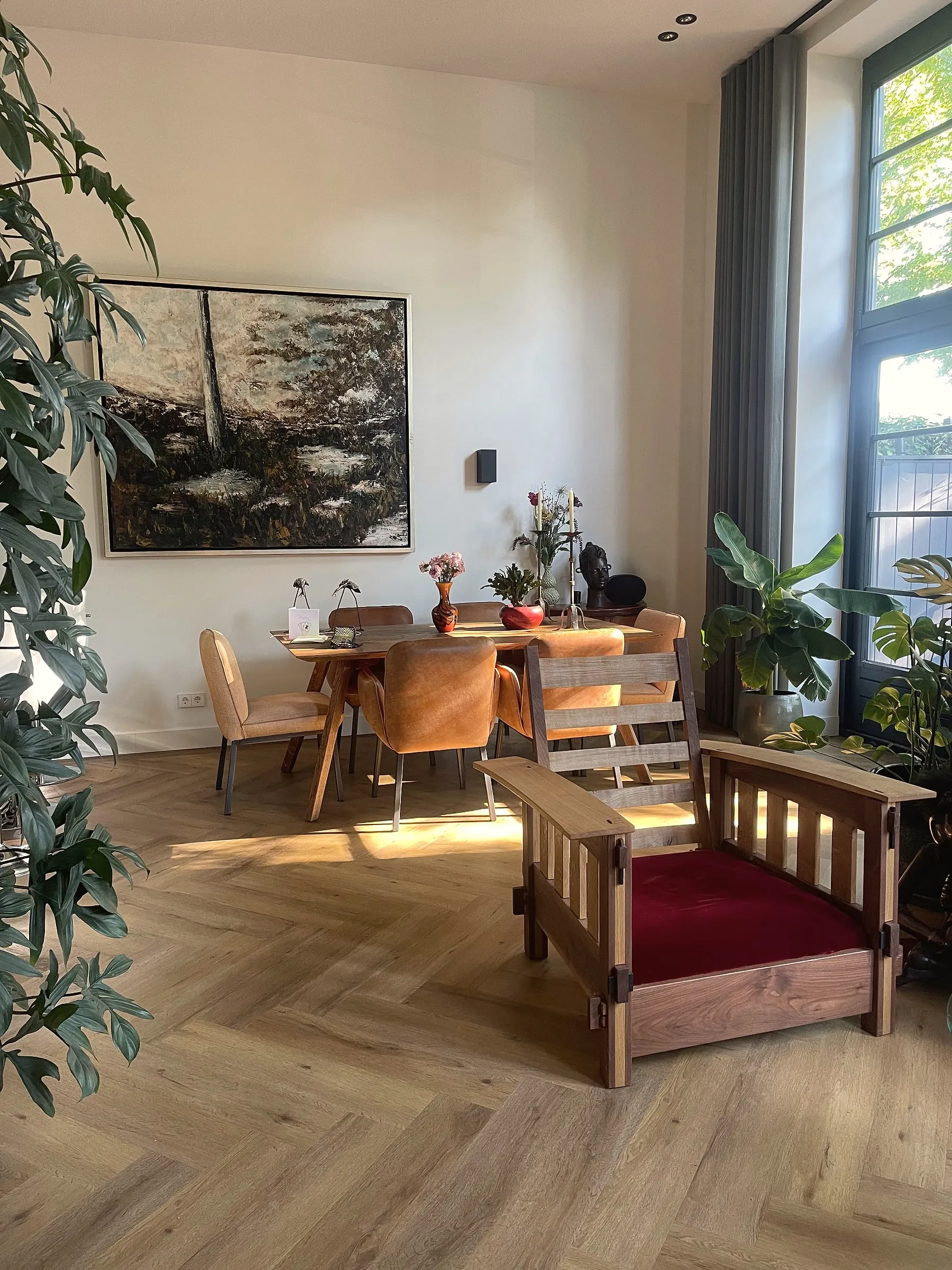 Fauteuil op maat met een houten spijlenframe en een rood fluwelen zitkussen, in een zonnige woonkamer met visgraatvloer