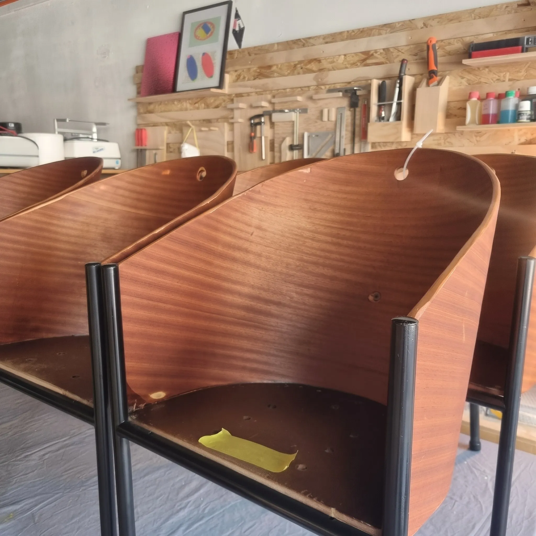 Close-up van Costes-stoelen in de werkplaats, met tape gemarkeerd voor restauratie