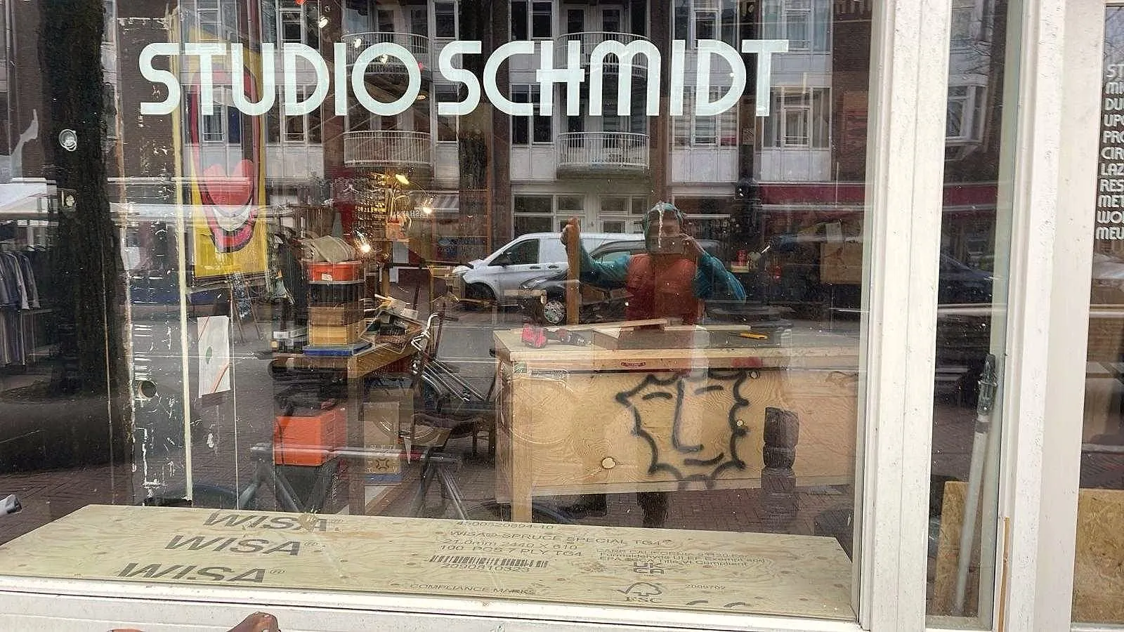 Etalage van Studio Schmidt met de Dapperstraat weerspiegeld in het glas